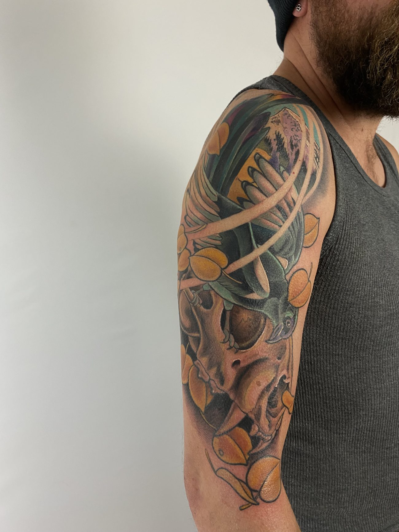 Black and grey skull and antler half-sleeve with organic elements