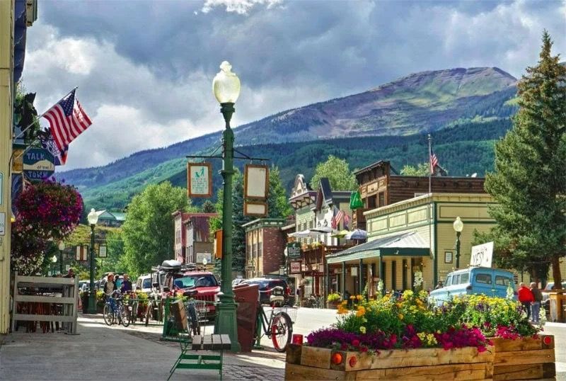 Historic storefronts and flower baskets along Elk Avenue in summer