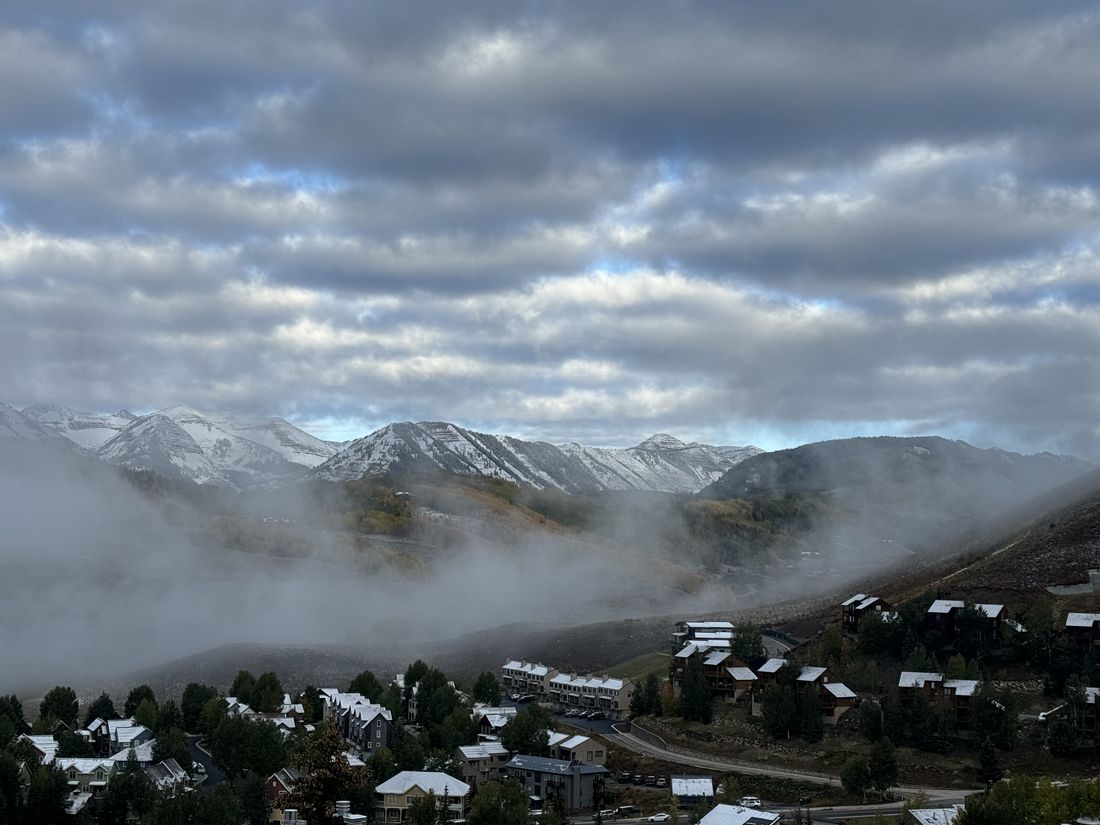 Low clouds drifting over the town and snow-dusted peaks